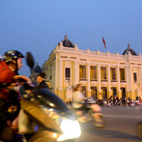 Bikers swirl past the historic Opera House